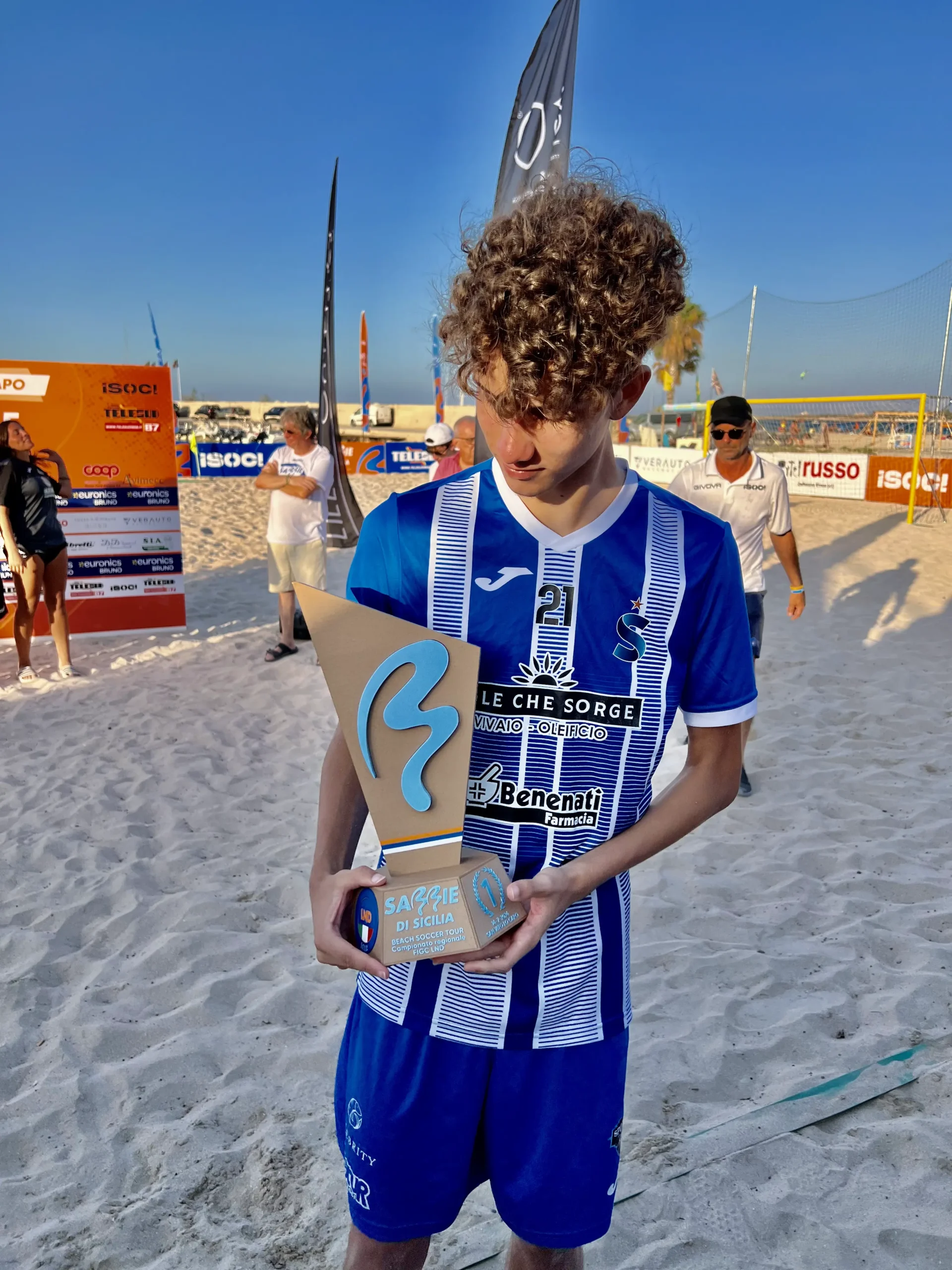 Foto de Eduardo Henrique, vulgo Dugol, segurando um trófeu em uma praia